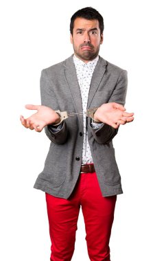 İzole arka plan üzerinde kelepçe ile sinirli yakışıklı adam