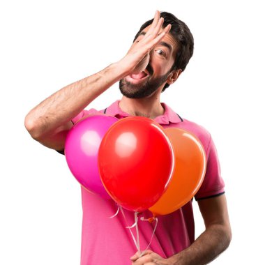 İzole beyaz arka plan üzerinde tutarak balon espri yakışıklı genç