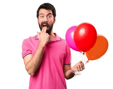Balonlar tutarak ve izole beyaz arka plan üzerinde kusma jest yapma yakışıklı delikanlı