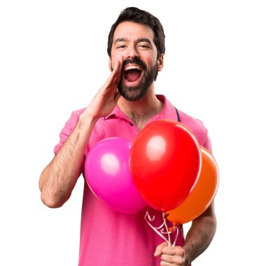 Balonlar ve bağırarak izole beyaz arka plan üzerinde tutarak yakışıklı genç