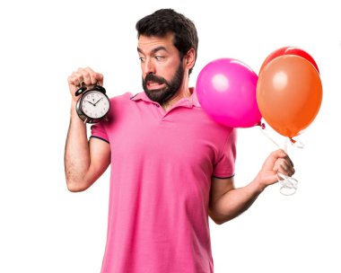Balonlar tutarak ve vintage saat izole beyaz arka plan üzerinde tutarak yakışıklı delikanlı