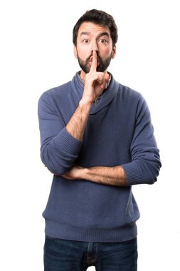Esmer yakışıklı beyaz arka plan üzerinde sakal yapma sessizlik hareketi ile