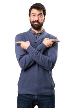 Beyaz arka plan üzerinde şüpheleri laterallerin işaret eden sakallı yakışıklı esmer adam