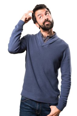 Beyaz arka plan üzerinde şüpheleri sakallı yakışıklı esmer adam