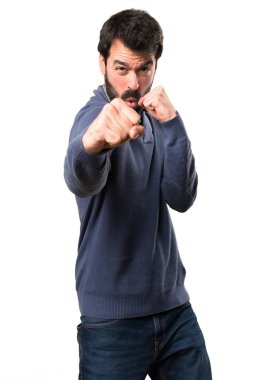 Beyaz arka plan üzerinde mücadele sakallı yakışıklı esmer adam