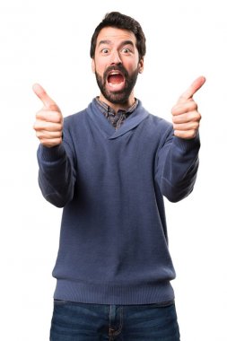 Beyaz arka plan üzerinde başparmak ile sakallı yakışıklı esmer adam