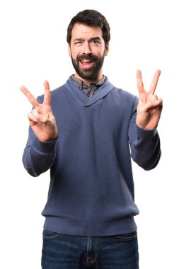 Esmer yakışıklı beyaz arka plan üzerinde sakal yapma zafer hareketi ile