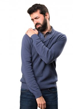 Beyaz arka plan üzerinde omuz ağrısı ile sakallı yakışıklı esmer adam