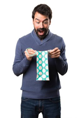 Beyaz arka plan üzerinde alışveriş çantası ile sakallı sürpriz yakışıklı esmer adam