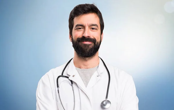 Onnellinen nuori lääkäri sinisellä taustalla — kuvapankkivalokuva