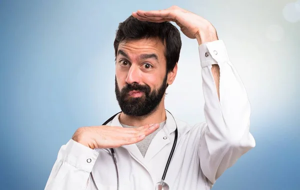 Young doctor focusing his face on blue background — Stock Photo, Image