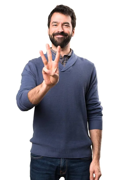 Knappe brunette man met baard tellen drie op witte achtergrond — Stockfoto
