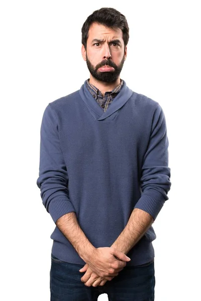 Triste bello bruna uomo con barba su sfondo bianco — Foto Stock