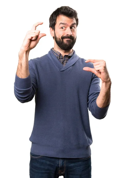 Handsome brunette man with beard making tiny sign on white background — Stock Photo, Image