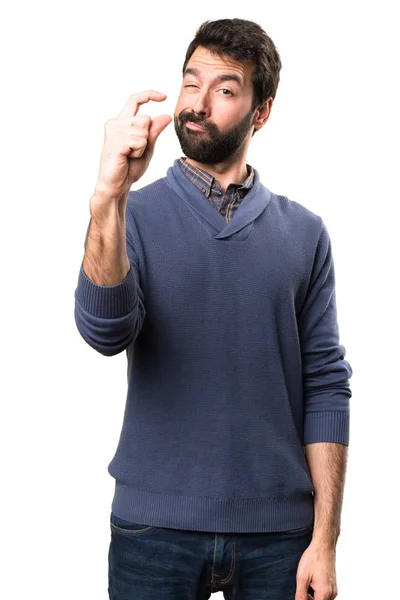 Hombre guapo morena con barba haciendo minúscula señal sobre fondo blanco — Foto de Stock