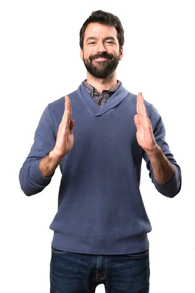 Hombre guapo morena con barba sosteniendo algo sobre fondo blanco — Foto de Stock