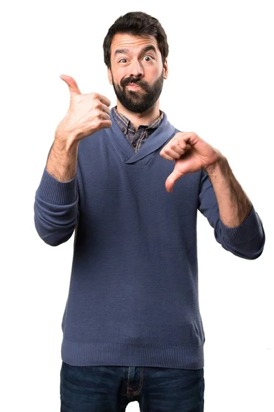 Schöner brünetter Mann mit Bart macht Gut-Böse-Zeichen auf weißem Hintergrund — Stockfoto