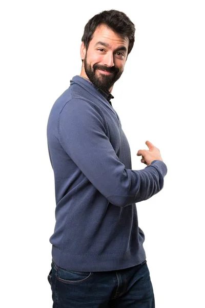 Bonito morena homem com barba apontando para trás no fundo branco — Fotografia de Stock