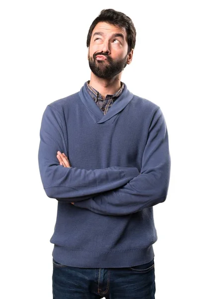 Guapo morena hombre con barba teniendo dudas sobre fondo blanco — Foto de Stock