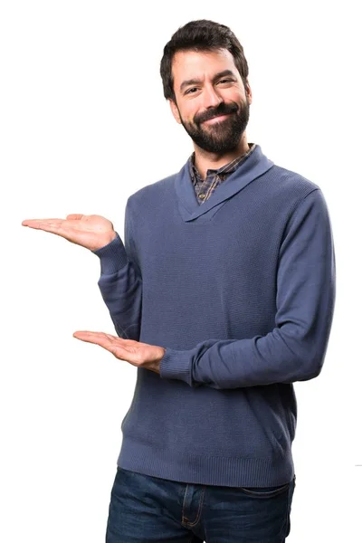 Bonito morena homem com barba apresentando algo no fundo branco — Fotografia de Stock