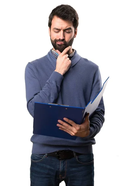 Beyaz arka plan üzerinde bir klasör tutan sakallı yakışıklı esmer adam — Stok fotoğraf