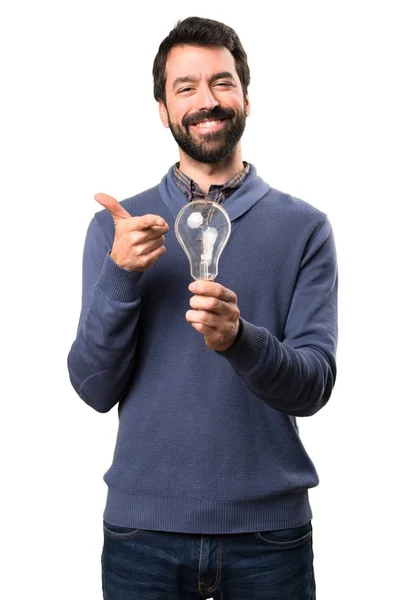 Feliz hombre guapo morena con barba sosteniendo una bombilla sobre fondo blanco —  Fotos de Stock