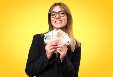 Renkli arka plan üzerinde bir sürü para alarak genç iş kadını