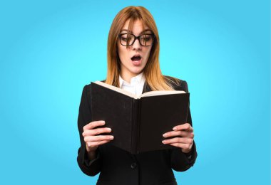 Genç iş kadını renkli arka plan üzerinde kitap okuma