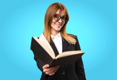 Genç iş kadını renkli arka plan üzerinde kitap okuma