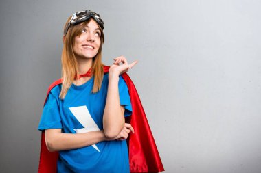 Gri dokulu bir arka plan üzerinde düşünme güzel süper kahraman kız