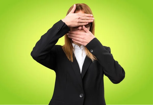 Jonge zakenvrouw die betrekking hebben op haar gezicht op kleurrijke achtergrond — Stockfoto
