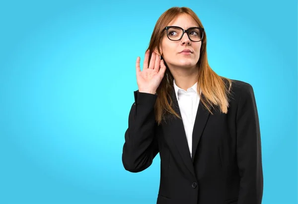 Joven mujer de negocios escuchando algo sobre fondo colorido —  Fotos de Stock