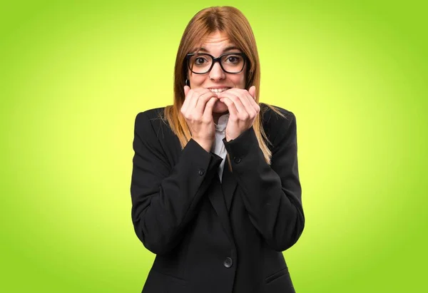 Mujer de negocios joven asustado en fondo colorido — Foto de Stock