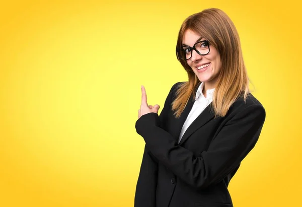 Jonge business woman wijzend naar kleurrijke achtergrond — Stockfoto