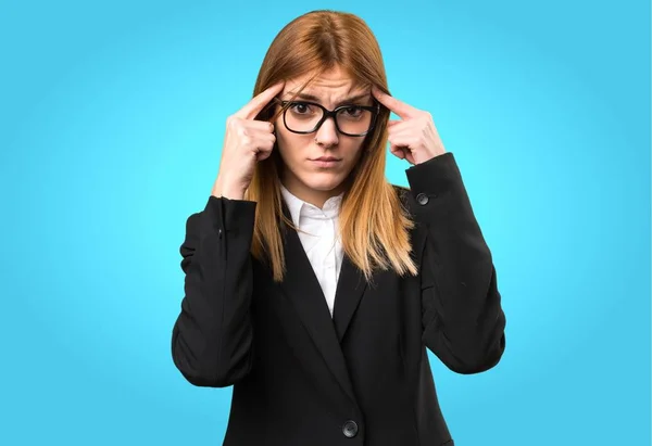 Joven mujer de negocios pensando en fondo colorido —  Fotos de Stock