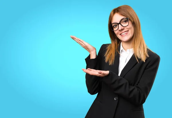 Joven mujer de negocios que presenta algo sobre fondo colorido —  Fotos de Stock