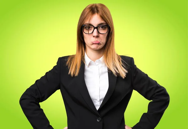 Traurige junge Geschäftsfrau auf buntem Hintergrund — Stockfoto