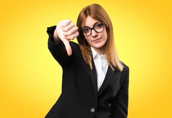 Joven mujer de negocios haciendo mala señal en el fondo colorido —  Fotos de Stock