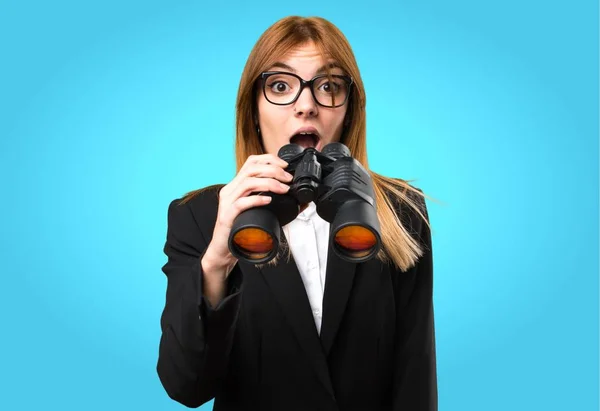 Young business woman with binoculars on colorful background — Stock Photo, Image