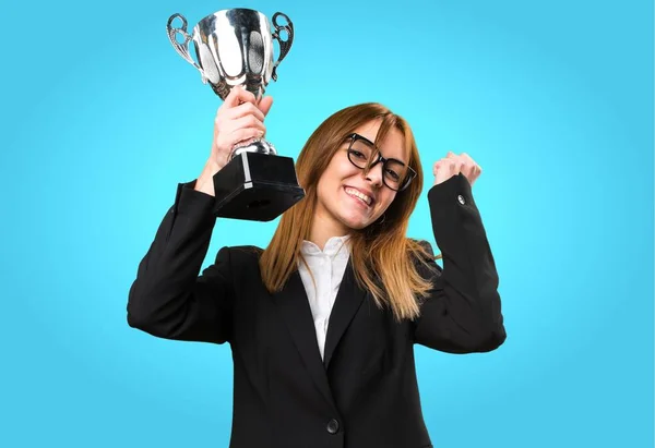 Giovane donna d'affari in possesso di un trofeo su sfondo colorato — Foto Stock
