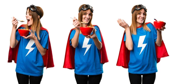 Hübsches Superheldenmädchen isst Müsli aus einer Schüssel — Stockfoto