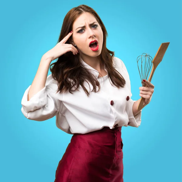 Beautiful chef woman making crazy gesture on colorful background