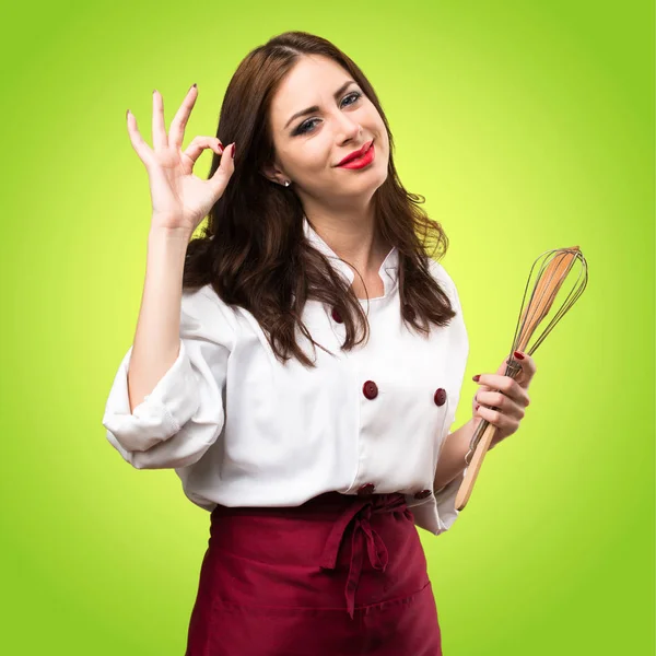 Mulher chef bonita fazendo sinal OK no fundo colorido — Fotografia de Stock
