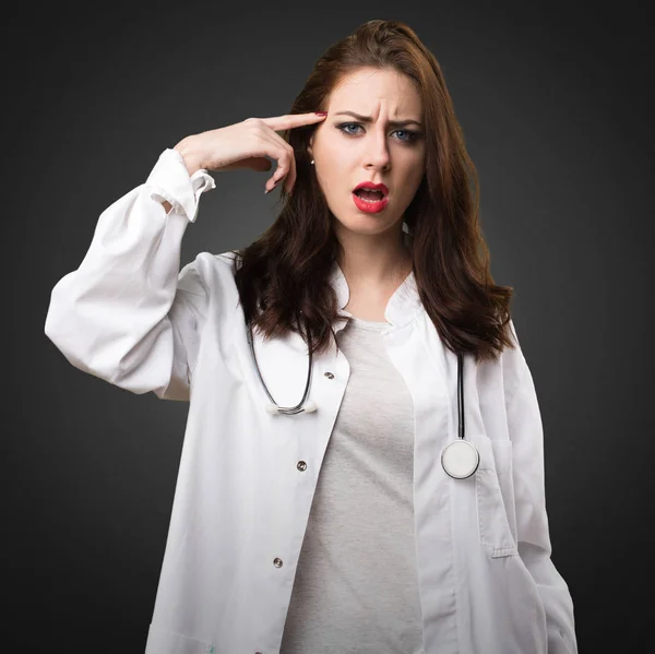 Läkare kvinna gör galen gest på svart bakgrund — Stockfoto