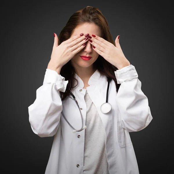 Dokter vrouw die betrekking hebben op haar ogen op zwarte achtergrond — Stockfoto