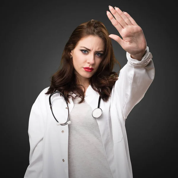 Läkare kvinna att göra stoppskylt på svart bakgrund — Stockfoto