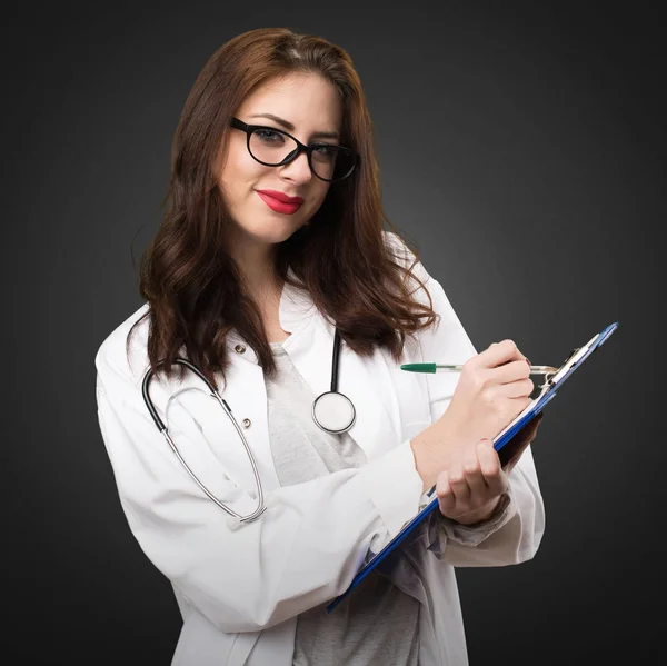 Женщина-врач держит папку на черном фоне — стоковое фото