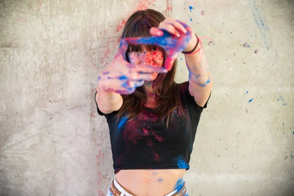 Menina bonita com holi cor focando com os dedos — Fotografia de Stock