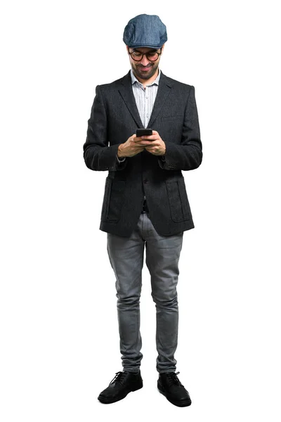 Schöner moderner Mann mit Baskenmütze und Brille im Gespräch mit Handy — Stockfoto