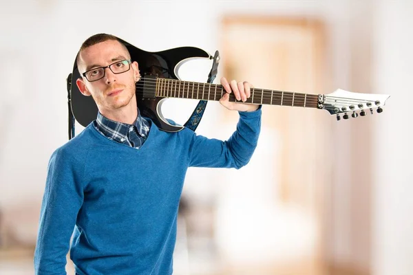Jonge man met zijn gitaar op witte achtergrond — Stockfoto